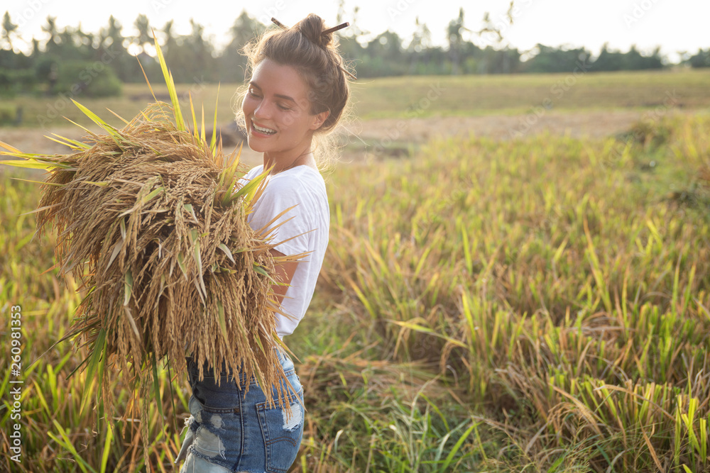Happy woman farmer during harvesting on the rice field